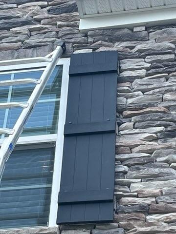 Custom dark shutters on stone facade